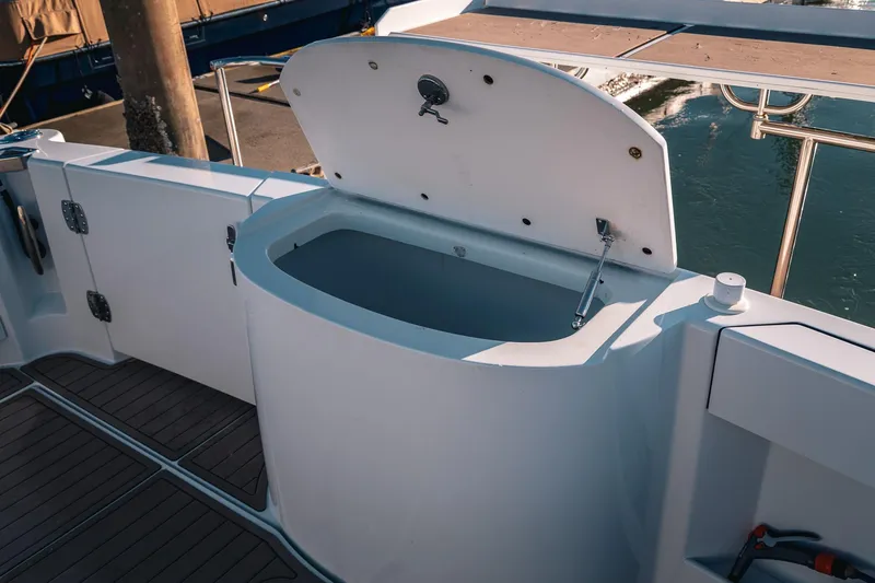 Slide: The Image of Open storage compartment on 2019 Lindell 46' boat deck, near water. - 58