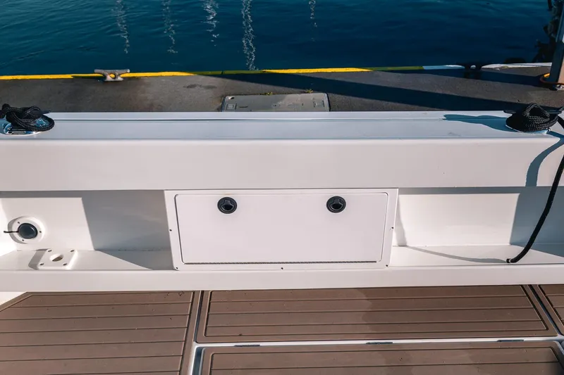 Slide: The Image of 2019 Lindell 46' boat deck with storage compartment, docked by calm water. - 59