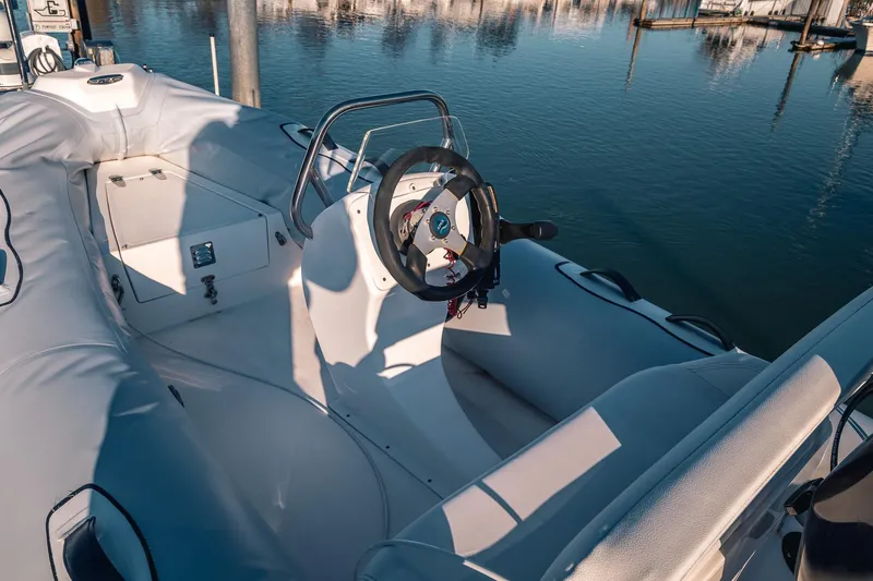 Slide: The Image of Interior view of a 2019 Lindell 46' boat, featuring a sleek steering wheel and seating. - 67