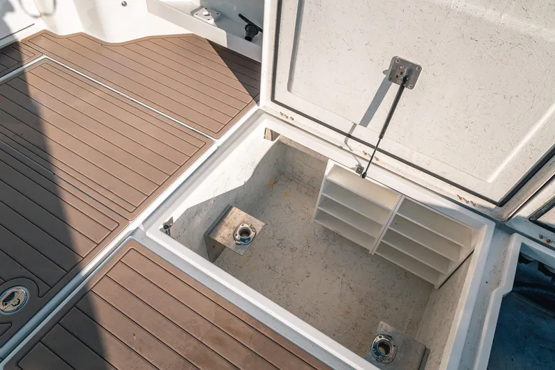 Slide: The Image of Open storage compartment on 2019 Lindell 46' boat with wooden deck flooring. - 76
