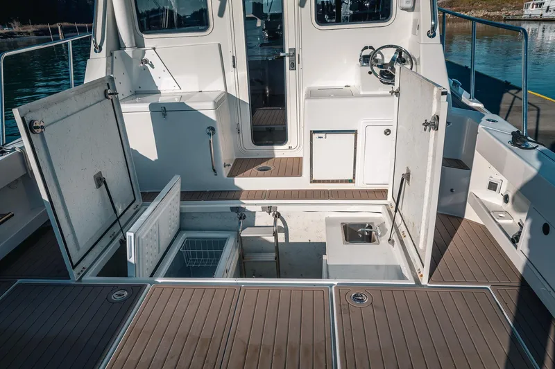 Slide: The Image of Open deck storage on a 2019 Lindell 46' boat with wooden flooring. - 77