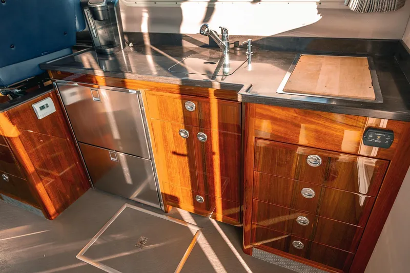 Slide: The Image of Luxurious 2019 Lindell 46' yacht kitchen with wood cabinetry and stainless steel appliances. - 9