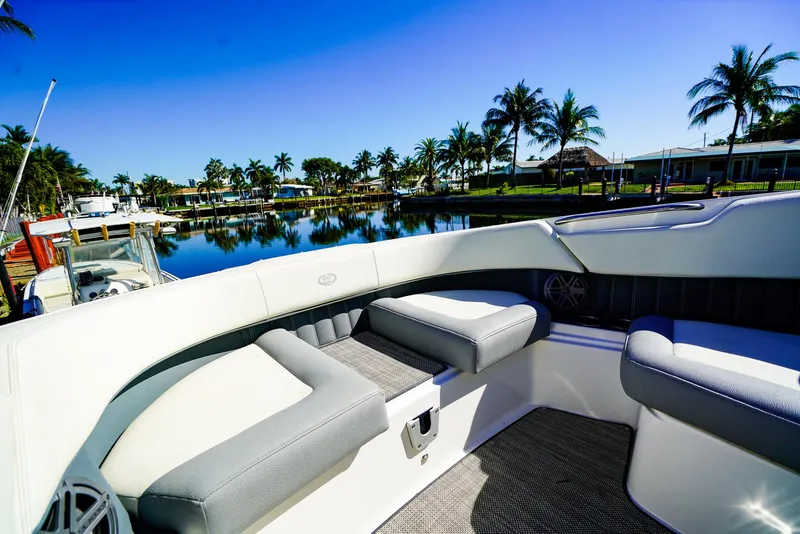 Slide: The Image of 2019 Cobalt 23SC boat interior with plush seating, docked by a scenic waterfront. - 20