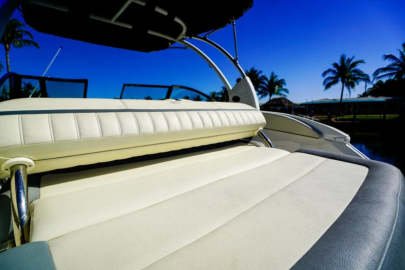Slide: The Image of 2019 Cobalt 23SC boat interior with white seating, palm trees, and blue sky background. - 8