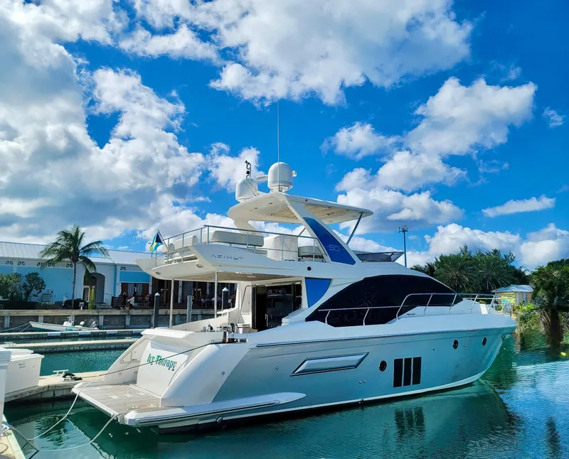 Slide: The Image of Luxury 2015 Azimut 50 yacht docked under a vibrant blue sky. - 1