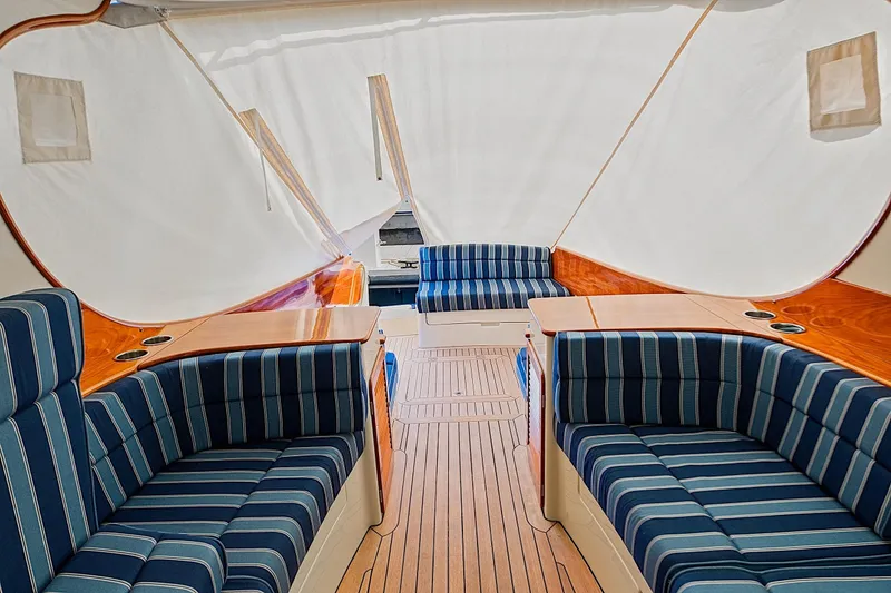 Slide: The Image of Interior of 2018 Hinckley Picnic Boat 37 MKIII with striped seating and wooden accents. - 28