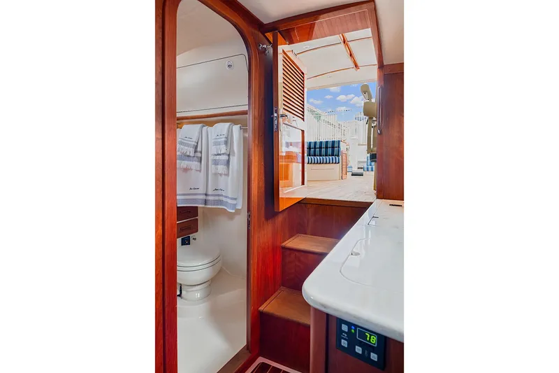 Slide: The Image of Interior of 2018 Hinckley Picnic Boat 37 MKIII, featuring a compact bathroom and wooden finishes. - 39