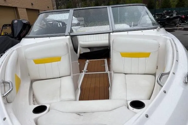 Slide: The Image of 2008 Regal 1900 Bowrider boat interior with white seats and wooden flooring. - 11