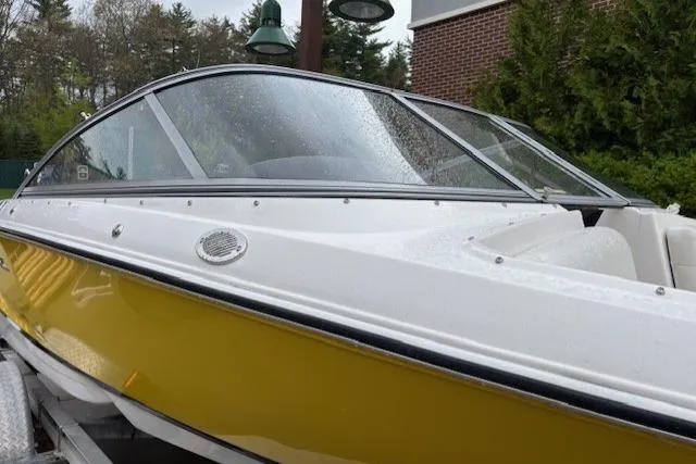 Slide: The Image of 2008 Regal 1900 Bowrider boat with yellow hull, parked outdoors on a trailer. - 12