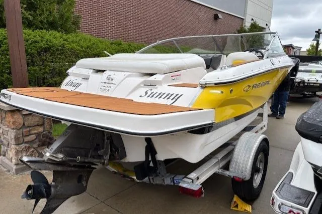 Slide: The Image of 2008 Regal 1900 Bowrider boat on trailer, yellow and white design, parked outdoors. - 13