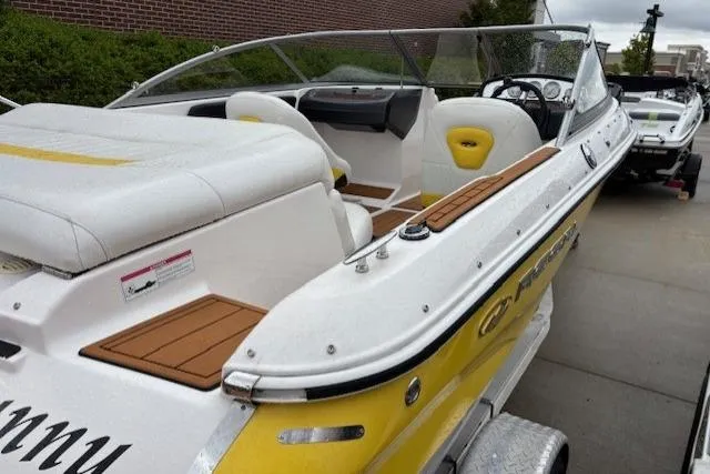 Slide: The Image of 2008 Regal 1900 Bowrider boat with yellow accents, parked on a trailer. - 14