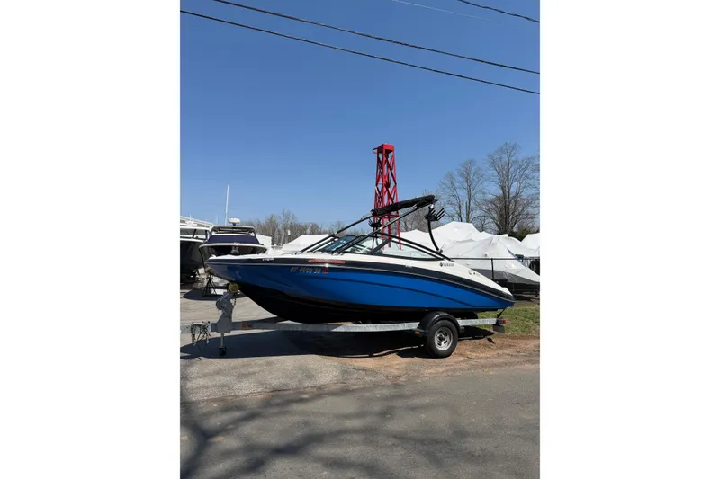 Slide: The Image of 2014 Yamaha Boats SX192 in blue, parked on a trailer under a clear sky. - 10