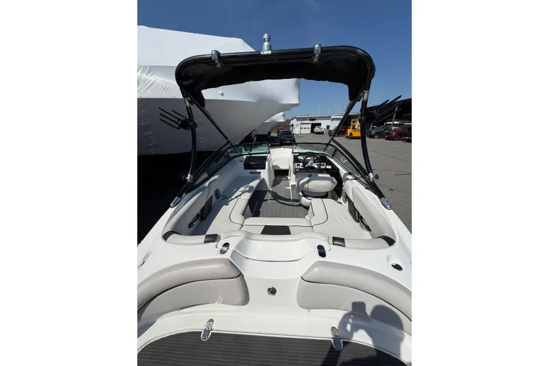 Slide: The Image of 2014 Yamaha Boats SX192 interior with seating and steering wheel, docked under clear sky. - 11
