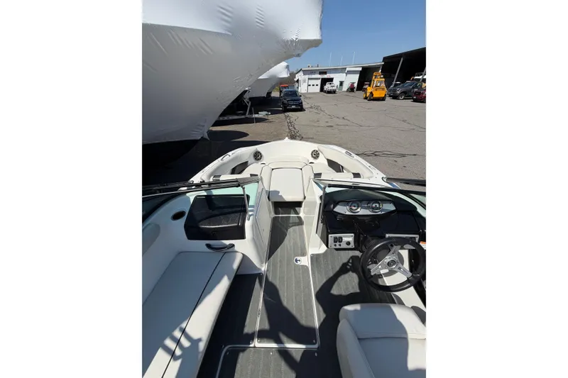 Slide: The Image of 2014 Yamaha Boats SX192 interior view at a marina, showcasing steering and seating area. - 13