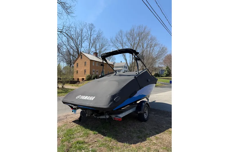 Slide: The Image of 2014 Yamaha SX192 boat on trailer, covered, parked near residential area. - 3