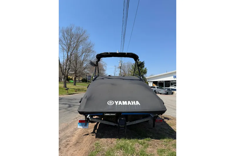 Slide: The Image of 2014 Yamaha Boats SX192 with cover, parked on roadside under clear blue sky. - 5