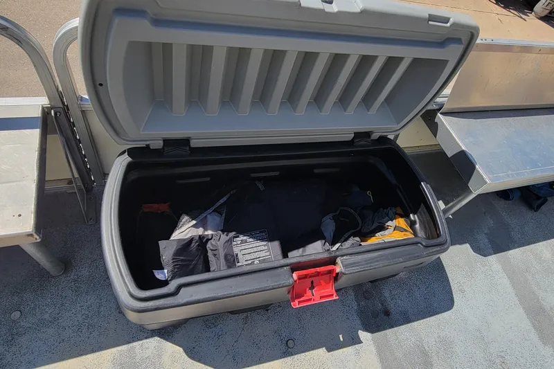Slide: The Image of Open storage compartment on a 2003 Odyssey Millennium boat, containing various items. - 11