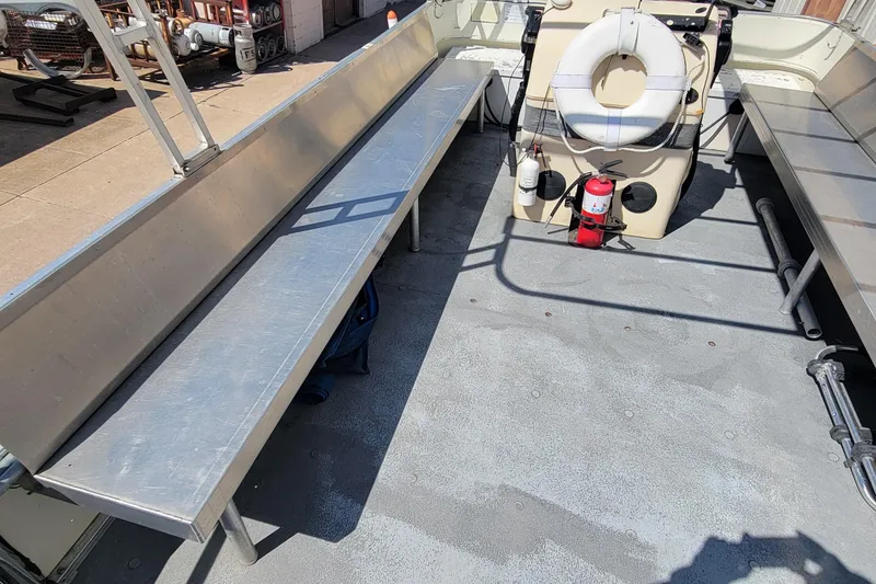 Slide: The Image of 2003 Odyssey Millennium boat interior with metal benches and safety equipment. - 12