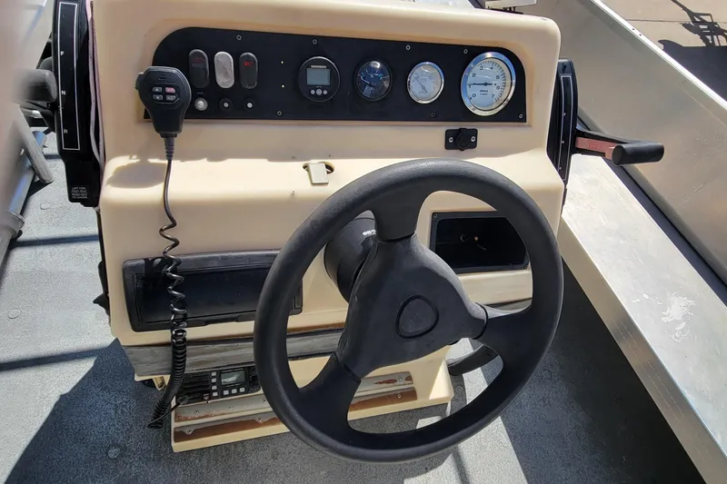 Slide: The Image of Steering console of a 2003 Odyssey Millennium boat with gauges and controls. - 15