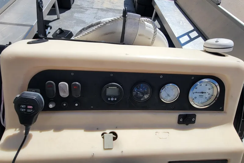 Slide: The Image of Control panel of a 2003 Odyssey Millennium boat with gauges and a microphone. - 18