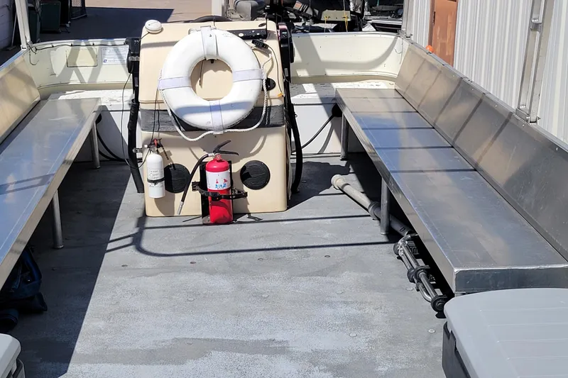 Slide: The Image of Interior of a 2003 Odyssey Millennium boat with benches and safety equipment. - 2