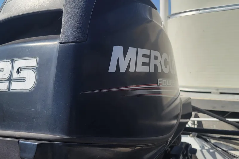 Slide: The Image of Outboard motor with "Mercury 25" branding on a 2003 Odyssey Millennium boat. - 21
