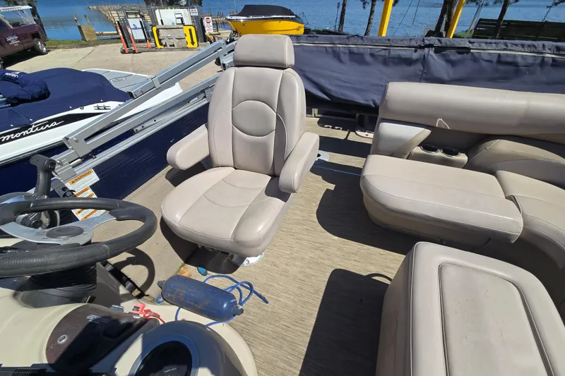 Slide: The Image of 2013 Starcraft Stardeck 236 Cruise-N-Fish boat interior with beige seating and steering wheel. - 11