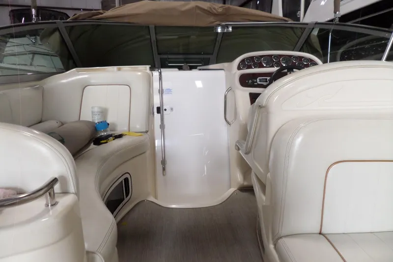 Slide: The Image of 1997 Sea Ray 290 Sundancer boat interior with white seating and dashboard controls. - 12