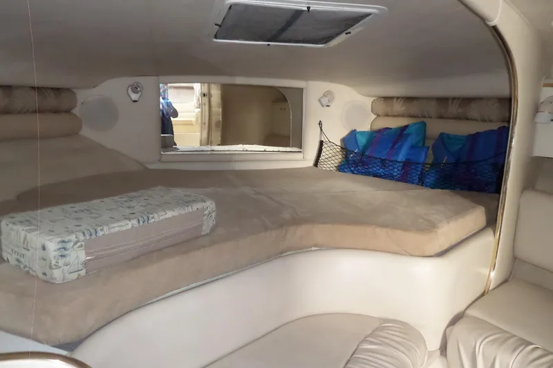 Slide: The Image of 1997 Sea Ray 290 Sundancer cabin interior with cozy sleeping area and cushions. - 25