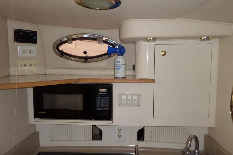 Slide: The Image of Interior of 1997 Sea Ray 290 Sundancer with microwave, cabinet, and porthole window. - 27