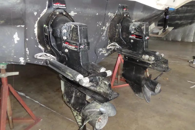 Slide: The Image of 1997 Sea Ray 290 Sundancer MerCruiser outdrives in a maintenance setting. - 3