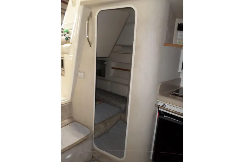 Slide: The Image of Interior of 1997 Sea Ray 290 Sundancer boat, featuring cabin entrance and kitchenette. - 30
