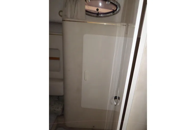 Slide: The Image of Interior cabin of 1997 Sea Ray 290 Sundancer boat, featuring a compact bathroom area. - 32