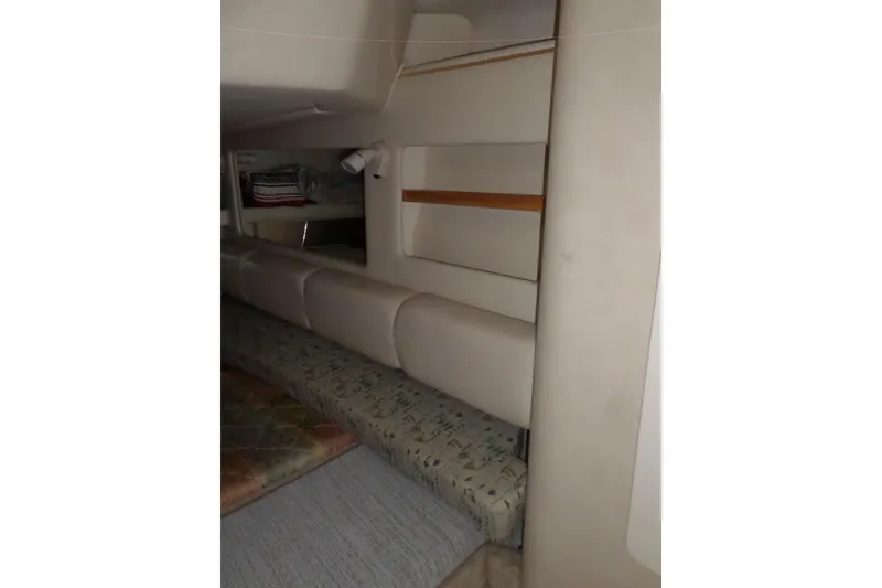Slide: The Image of Interior cabin of 1997 Sea Ray 290 Sundancer with beige upholstery and compact design. - 33