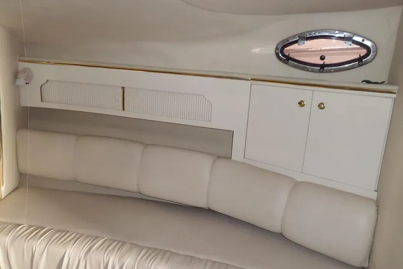 Slide: The Image of Interior of 1997 Sea Ray 290 Sundancer with white seating and storage cabinets. - 37