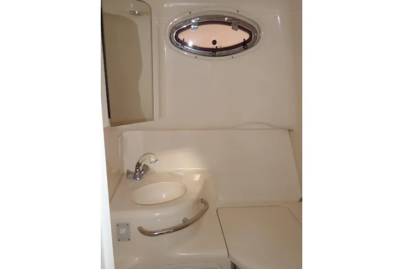 Slide: The Image of 1997 Sea Ray 290 Sundancer bathroom with sink, mirror, and porthole window. - 40