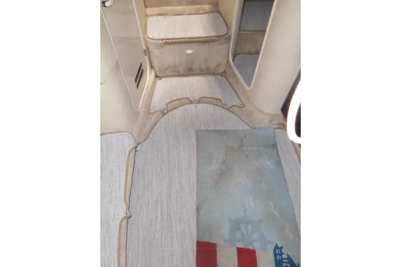 Slide: The Image of Interior view of a 1997 Sea Ray 290 Sundancer boat cabin with carpeted flooring. - 44