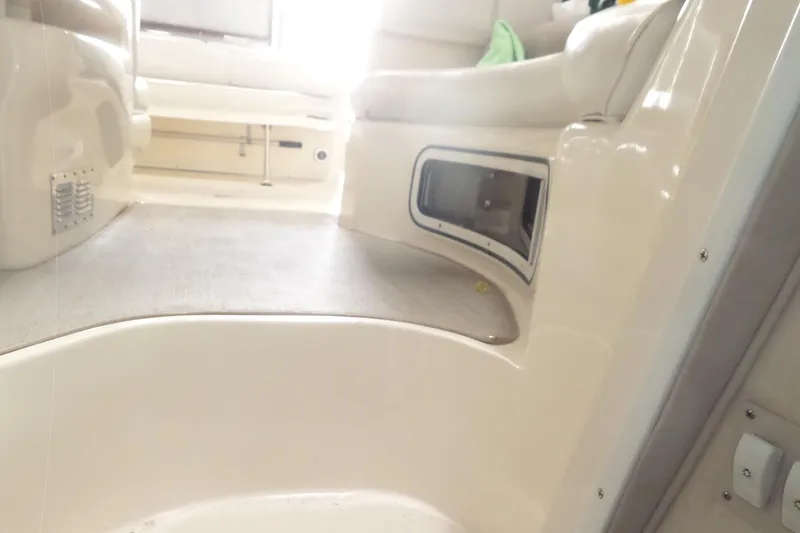 Slide: The Image of Interior view of a 1997 Sea Ray 290 Sundancer boat, featuring seating and storage. - 45