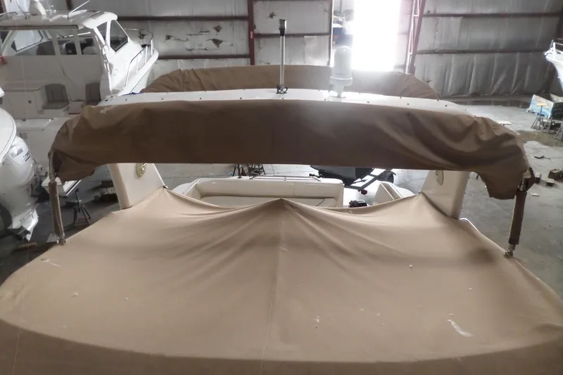Slide: The Image of 1997 Sea Ray 290 Sundancer boat with tan canvas cover in storage. - 55