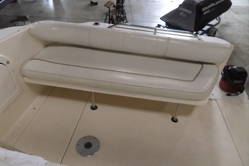 Slide: The Image of 1997 Sea Ray 290 Sundancer boat interior with white cushioned seating. - 6