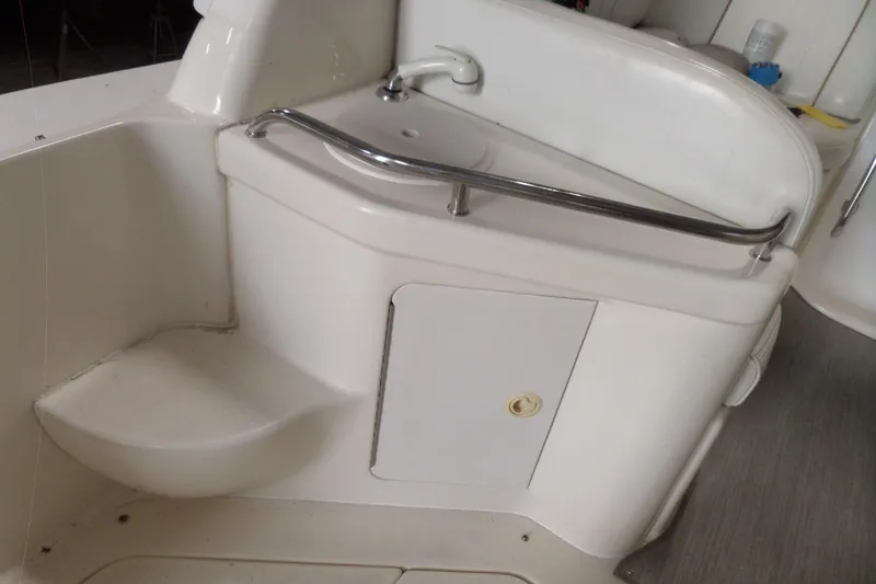 Slide: The Image of 1997 Sea Ray 290 Sundancer boat interior with sink and storage compartment. - 8