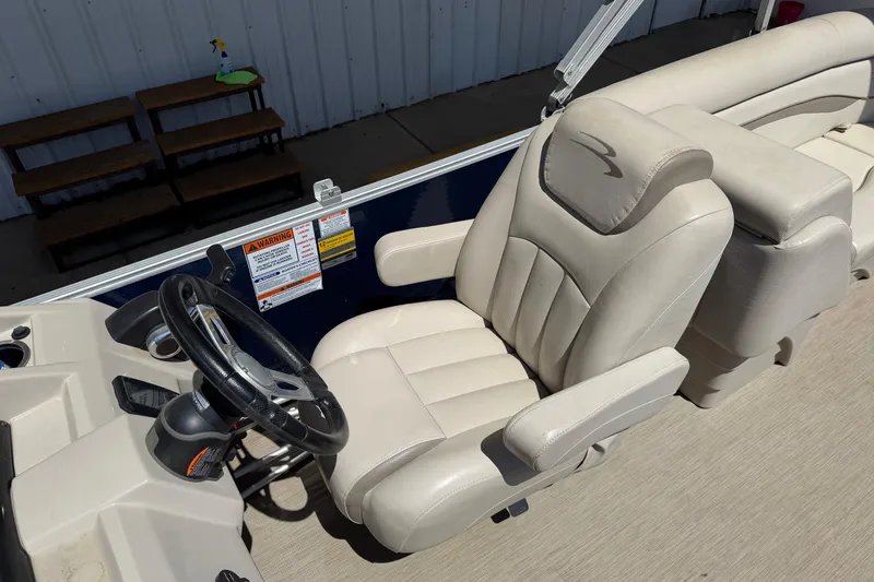 Slide: The Image of 2017 Bennington SX 22 Quad Bench boat interior with beige captain's chair and steering wheel. - 12