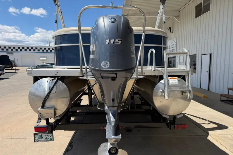Slide: The Image of 2017 Bennington SX 22 Quad Bench pontoon boat with Yamaha 115 engine, parked outdoors. - 4