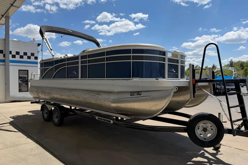 Slide: The Image of 2017 Bennington SX 22 Quad Bench pontoon boat on trailer under blue sky. - 7