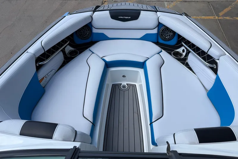 Slide: The Image of 2019 Nautique Super Air Nautique GS22 boat interior with blue and white seating. - 13