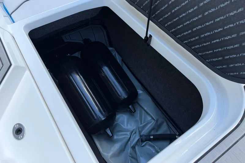 Slide: The Image of Storage compartment of 2019 Nautique Super Air Nautique GS22 with black fenders. - 15