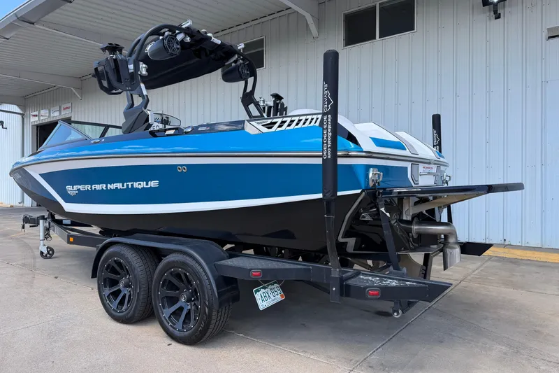 Slide: The Image of 2019 Nautique Super Air Nautique GS22 boat on trailer, parked outside a building. - 3
