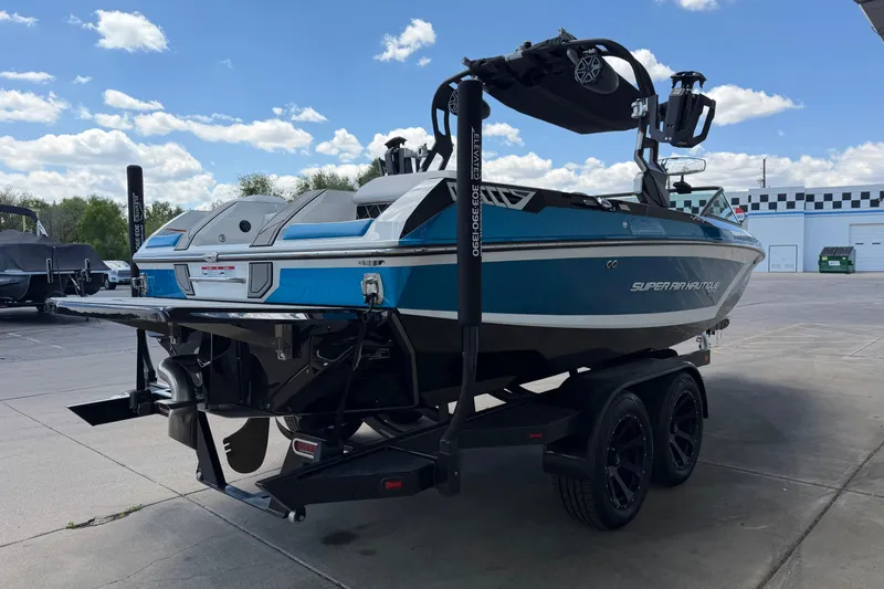 Slide: The Image of 2019 Nautique Super Air Nautique GS22 boat on trailer, parked outdoors under a blue sky. - 5
