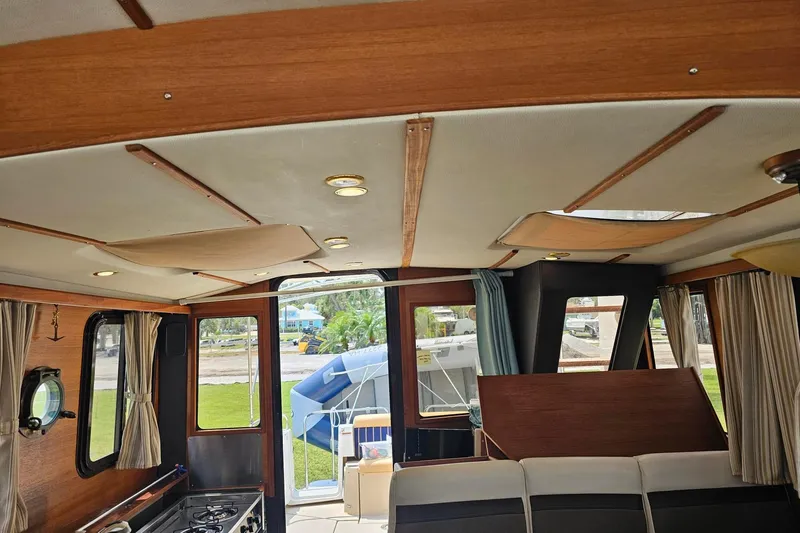 Slide: The Image of Interior of 2014 Ranger Tugs R-31 CB boat, featuring wood paneling and windows. - 11