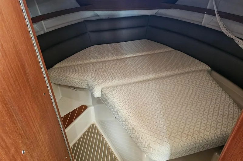 Slide: The Image of 2014 Ranger Tugs R-31 CB cabin interior with cushioned bed and wooden accents. - 14